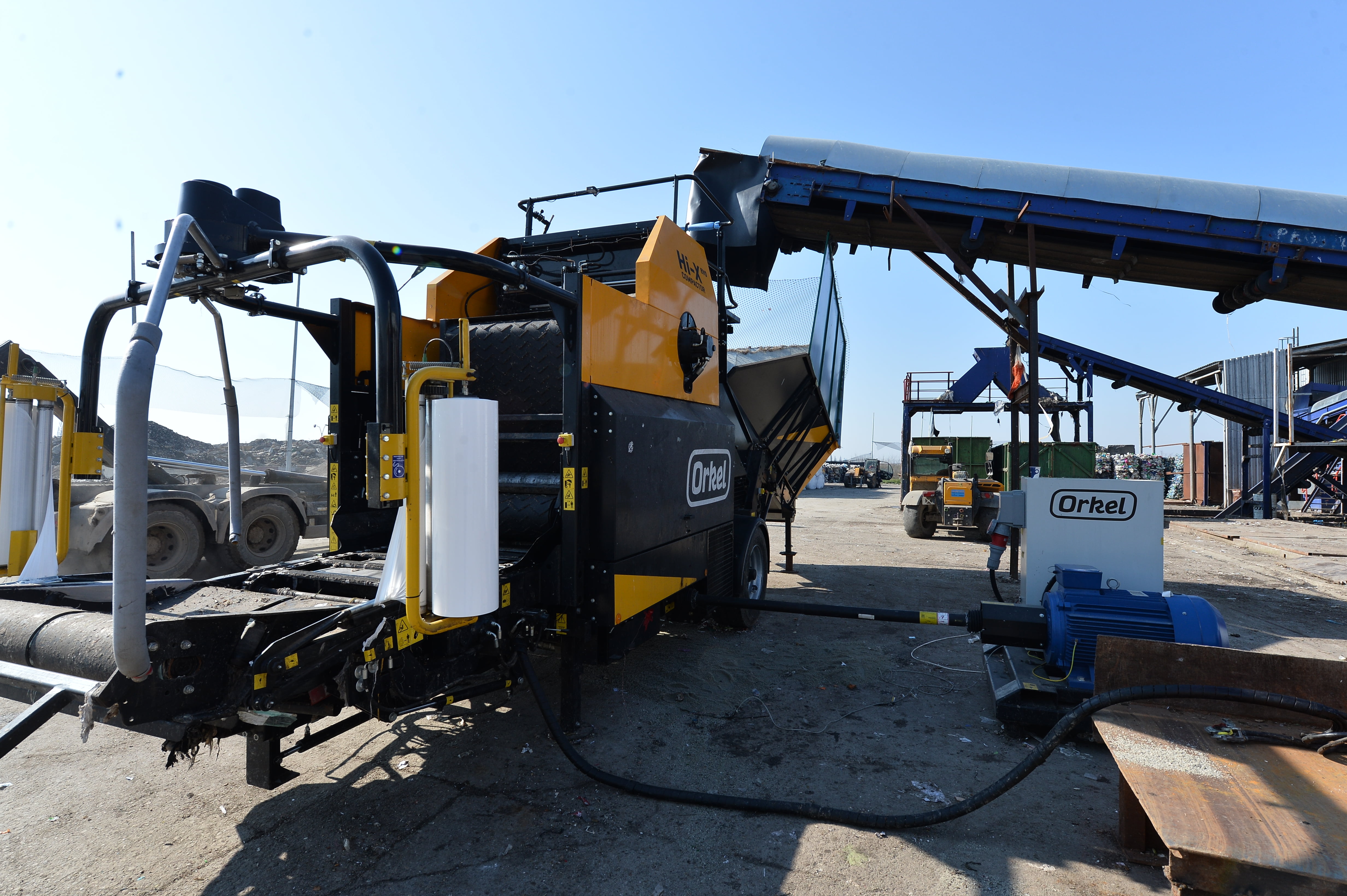 Waste management with Orkel: A Hi-X evo compactor in an industrial location under a blue sky