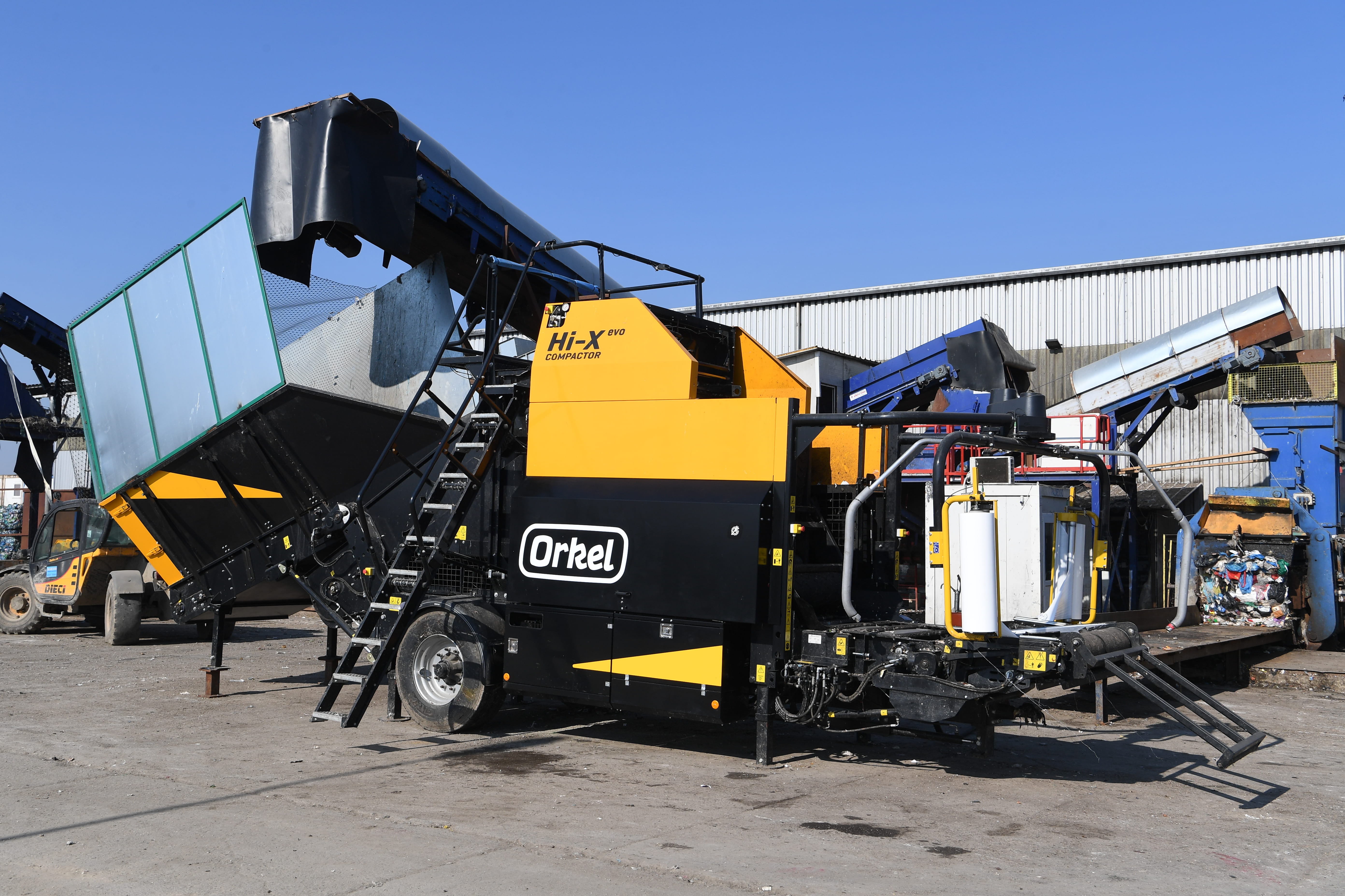 A Hi-X evo compactor in an industrial location under a blue sky.