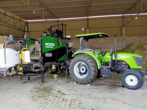 Tractor connected to an Orkel MC850 compactor during baling